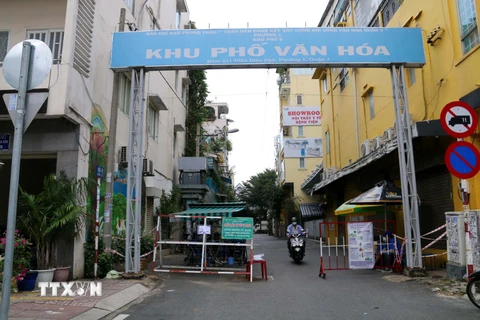 Tháo gỡ một phần rào chắn, tạo lối đi ở hẻm 611 đường Điện Biên Phủ, Quận 3, Thành phố Hồ Chí Minh. (Ảnh: Thanh Vũ/TTXVN)