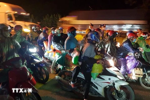 Lực lượng chức năng tỉnh Ninh Bình hỗ trợ công dân đi xe môtô qua địa bàn. (Ảnh: Đức Phương/TTXVN)
