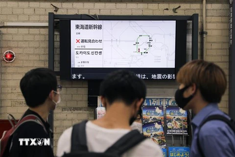 Người dân theo dõi thông tin về lịch trình các chuyến tàu bị hoãn ở nhà ga Tokyo, Nhật Bản do ảnh hưởng của động đất, ngày 7/10/2021. (Ảnh: THX/TTXVN)