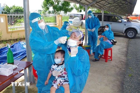 Nhân viên y tế lấy mẫu xét nghiệm đối với các công dân từ Thành phố Hồ Chí Minh trở về Bạc Liêu. (Ảnh: Chanh Đa/TTXVN)
