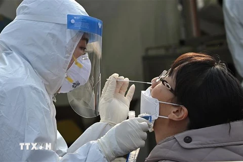 Nhân viên y tế lấy mẫu xét nghiệm COVID-19 cho người dân tại Seoul, Hàn Quốc. (Ảnh: AFP/TTXVN)