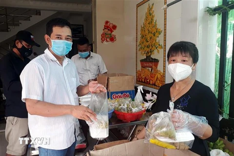 Anh Trần Phước Lành và vợ là chị Huỳnh Thị Thu Hằng chuẩn bị 130 phần cơm hỗ trợ người dân cách ly tập trung mỗi ngày. (Ảnh: TTXVN phát)