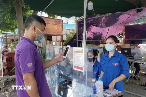  Người dân khai báo y tế bằng mã QR tại chốt kiểm soát dịch COVID-19 số 1 cầu Xuân Phương thành phố Phúc Yên. (Ảnh: Hoàng Hùng/TTXVN)