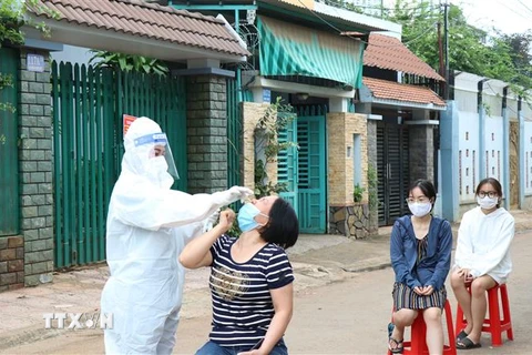 Lực lượng chức năng lấy mẫu xét nghiệm sàng lọc SARS-CoV-2 tại đường Ama Khê, phường Tân Lập, thành phố Buôn Ma Thuột, tỉnh Đắk Lắk. (Ảnh: Tuấn Anh/TTXVN)