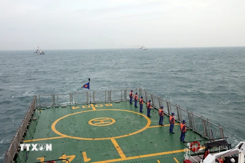 Cảnh sát biển hai nước Việt Nam và Trung Quốc thực hiện nghi thức chào xã giao trên biển. (Ảnh: TTXVN phát)