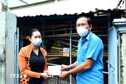Liên đoàn Lao động Bình Tân trao quà hỗ trợ cho công nhân, người lao động có hoàn cảnh khó khăn ở khu trọ bị ảnh hưởng bởi dịch COVID-19. (Ảnh: Thanh Vũ/TTXVN)