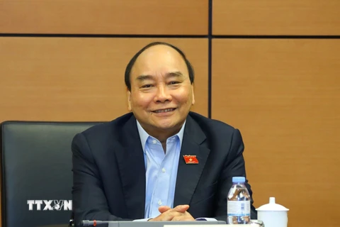 Chủ tịch nước Nguyễn Xuân Phúc, đại biểu Quốc hội Thành phố Hồ Chí Minh thảo luận ở tổ. (Ảnh: Văn Điệp/TTXVN)