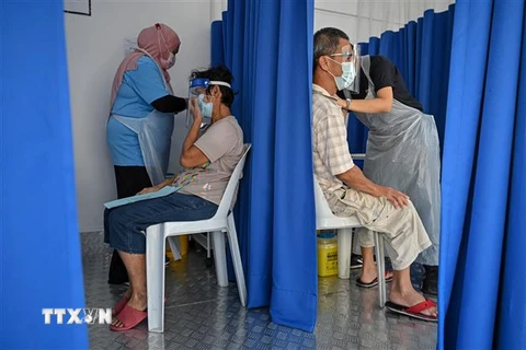 Nhân viên y tế tiêm vaccine phòng COVID-19 cho người dân tại Kuala Lumpur, Malaysia. (Ảnh: AFP/TTXVN)