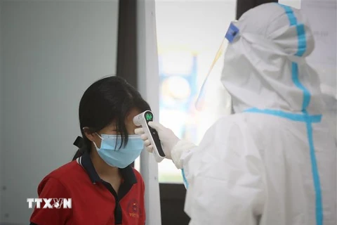 Nhân viên y tế theo dõi sức khỏe của các em nhỏ trong khu cách ly tập trung tại Trường Mầm non Thượng Lan (xã Thượng Lan, huyện Việt Yên, tỉnh Bắc Giang). (Ảnh: Danh Lam/TTXVN)