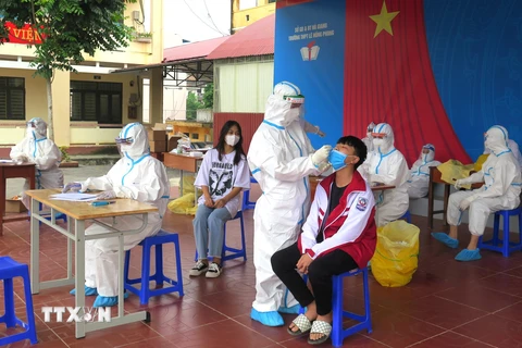 Lực lượng y tế thực hiện lấy mẫu xét nghiệm test nhanh học sinh Trường THPT Lê Hồng Phong (thành phố Hà Giang). (Ảnh: Minh Tâm/TTXVN)