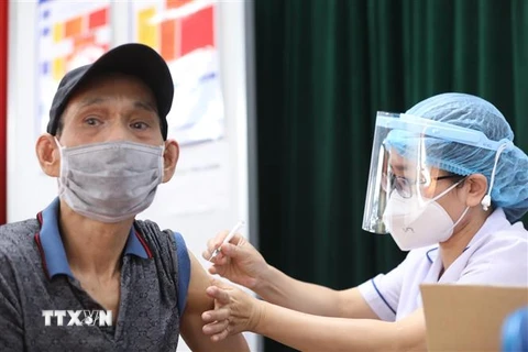 Nhân viên y tế tiêm vaccine phòng COVID-19 cho người dân tại điểm tiêm chủng quận Hai Bà Trưng (Hà Nội). (Ảnh: Minh Quyết/TTXVN)