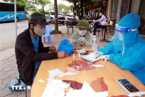Người dân phải khai báo y tế, test nhanh COVID-19 khi đến khu vực ngõ 587, đường Trần Nhân Tông, phường Vị Hoàng, thành phố Nam Định. (Ảnh: Nguyễn Lành/TTXVN)