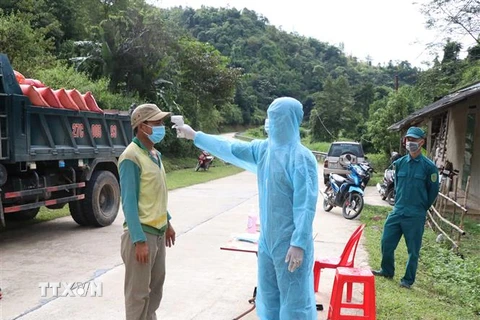 Lực lượng chức năng chốt kiểm soát phòng, chống dịch bản Hát Tao (xã Na Tông, huyện Điện Biên, tỉnh Điện Biên) kiểm tra thân nhiệt lái xe tải qua chốt. (Ảnh: Xuân Tiến/TTXVN)