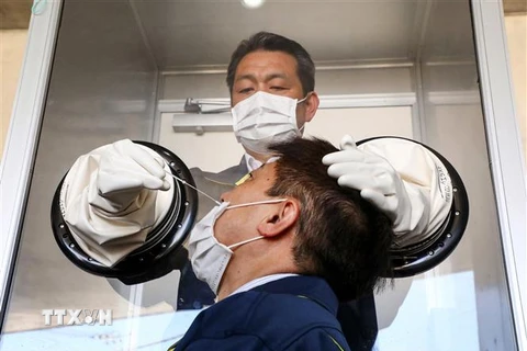 Nhân viên y tế lấy mẫu xét nghiệm COVID-19 tại Yokosuka, Kanagawa, Nhật Bản. (Ảnh: AFP/TTXVN)