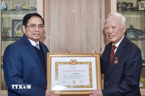Thủ tướng Phạm Minh Chính trao Huy hiệu 60 năm tuổi Đảng tặng ông Vũ Khoan. (Ảnh: TTXVN phát)