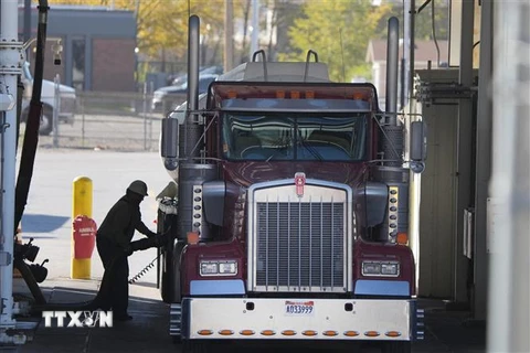 Lái xe tải bơm đầy xăng cho phương tiện tại một cơ sở lọc dầu ở Salt Lake City, bang Utah, Mỹ ngày 29/10/2021. (Ảnh: AFP/TTXVN)