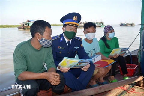 Thượng tá Nguyễn Văn Hiển tuyên truyền IUU cho bà con ngư dân Đồ Sơn. (Ảnh: TTXVN phát)