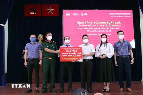 Ông Phạm Minh Tuấn (thứ 3 từ phải sang), Phó Chủ tịch Ủy ban MTTQ Việt Nam Thành phố Hồ Chí Minh, tiếp nhận tượng trưng 100.000 túi an sinh từ đại diện Tập đoàn Viettel và Ngân hàng Quân đội. (Ảnh: Xuân Khu/TTXVN)