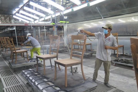 Công nhân phun sơn cho lô ghế xuất khẩu vào thị trường châu Âu. (Ảnh: Minh Hưng/TTXVN)