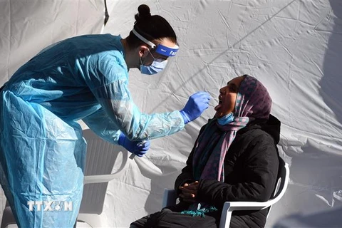 Nhân viên y tế lấy mẫu xét nghiệm COVID-19 cho người dân tại Melbourne, Australia. (Ảnh: AFP/TTXVN)