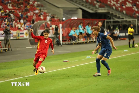 Cầu thủ Quang Hải dẫn bóng trước sự đeo bám của cầu thủ đội Thái Lan. (Ảnh: Thế Vũ/TTXVN)