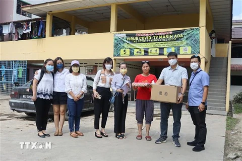 Đại diện Đại sứ quán Việt Nam tại Malaysia, Ban liên lạc người Việt bang Selangor và các tổ chức thiện nguyện trao quà cho lao động Việt Nam bị ảnh hưởng bởi lũ lụt tại Klang, Selangor. (Ảnh: Mạnh Tuân/TTXVN)