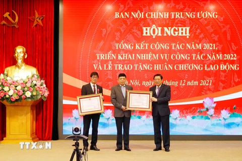 Ông Phan Đình Trạc, Ủy viên Bộ Chính trị, Bí thư Trung ương Đảng, Trưởng Ban Nội chính Trung ương trao Huân chương Lao động cho các cá nhân. (Ảnh: Phương Hoa/TTXVN)