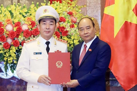 Chủ tịch nước Nguyễn Xuân Phúc trao Quyết định thăng cấp bậc hàm từ Trung tướng lên Thượng tướng đối với Thứ trưởng Bộ Công an Trần Quốc Tỏ. (Ảnh: Thống Nhất/TTXVN)