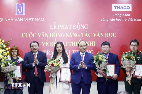 Chủ tịch nước Nguyễn Xuân Phúc trao giải thưởng cho các tác giả trẻ. (Ảnh: Thống Nhất/TTXVN)