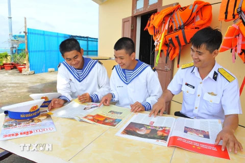 Các chiến sỹ đọc báo trên đảo Tốc Tan. (Ảnh: Minh Đức/TTXVN)