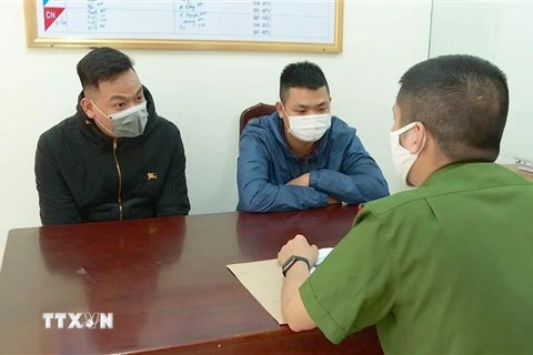 Hai đối tượng Nguyễn Anh Tuấn (trái) và Lê Văn (phải) tại cơ quan điều tra. (Ảnh: TTXVN phát)