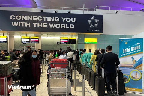 Hành khách hồ hởi chờ làm thủ tục lên máy bay của Vietnam Airlines tại sân bay Heathrow để về Việt Nam đón tết Nguyên đán Nhâm Dần. (Ảnh: Đình Thư/Vietnam+)
