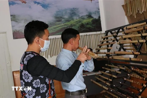 Anh Ma A Cháng, ở bản Sin Câu, xã Giang Ma, huyện Tam Đường hướng dẫn khách hàng thổi sáo. (Ảnh: Việt Hoàng/TTXVN)