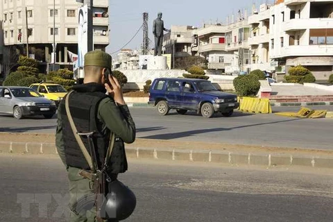 Lực lượng an ninh Chính phủ Syria gác tại một trạm kiểm soát ở Homs. (Nguồn: AFP/TTXVN)