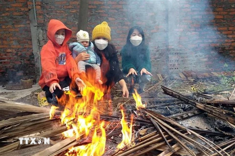 Người dân đốt lửa sưởi ấm trong tiết trời lạnh giá. (Ảnh: Hoàng Hùng/TTXVN)
