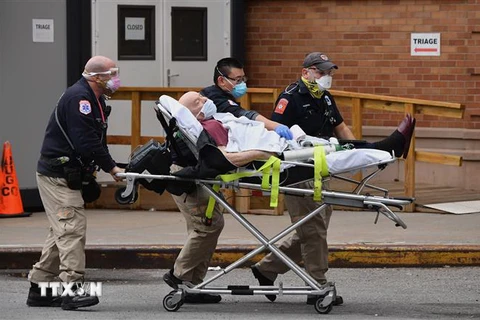 Nhân viên y tế chuyển bệnh nhân COVID-19 vào bệnh viện ở New York, Mỹ. (Ảnh: AFP/TTXVN)