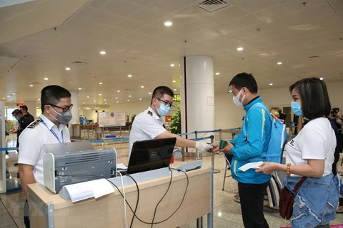 Làm thủ tục nhập cảnh tại cửa khẩu Sân bay quốc tế Nội Bài. (Ảnh: TTXVN)