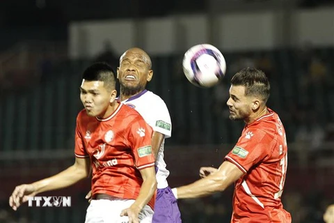 Pha tranh bóng giữa các cầu thủ đội Câu lạc bộ Thành phố Hồ Chí Minh (áo đỏ) và cầu thủ đội bóng Becamex Bình Dương (áo trắng). (Ảnh: Thanh Vũ/TTXVN)