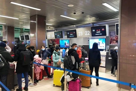 Công dân Việt Nam làm thủ tục tại sân bay Henri Coandă ở thủ đô Bucharest của Romania để về nước. (Ảnh: CTV/Vietnam+)