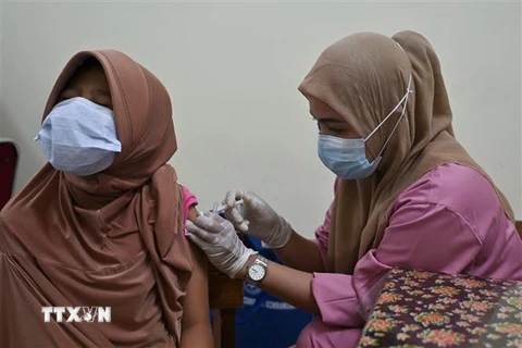 Nhân viên y tế tiêm vaccine ngừa COVID-19 cho người dân tại Jakarta, Indonesia. (Ảnh: AFP/TTXVN)