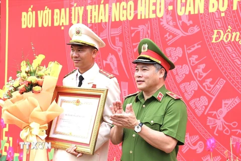 Thiếu tướng Nguyễn Văn Long, Thứ trưởng Bộ Công an trao Huân chương Dũng cảm cho Đại úy Thái Ngô Hiếu. (Ảnh: TTXVN phát)