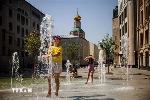Người dân giải nhiệt tại đài phun nước trong thời tiết nắng nóng ở Moskva, Nga mùa Hè năm 2021. (Ảnh: AFP/TTXVN)