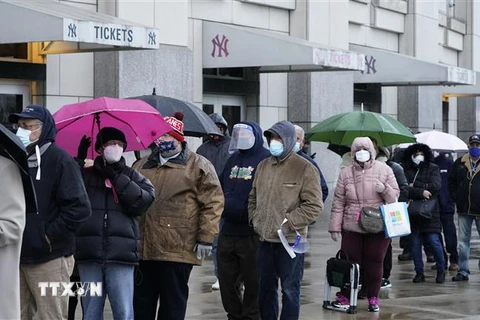 Người dân đeo khẩu trang phòng lây nhiễm COVID-19 tại một điểm tiêm chủng ở Mỹ. (Ảnh: AFP/TTXVN)