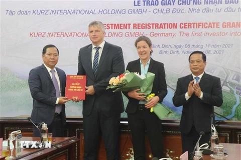 Lãnh đạo tỉnh Bình Định trao giấy chứng nhận đầu tư cho đại diện Tập đoàn KURZ về dự án nhà máy sản xuất tại Bình Định hồi tháng 11/2021. (Ảnh: Phạm Kha/TTXVN)