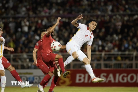 Pha tranh bóng giữa các tuyển thủ Việt Nam (áo trắng) với các cầu thủ Afghanistan. (Ảnh: Thanh Vũ/TTXVN)