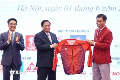 Đại diện Đoàn thể thao Việt Nam tặng lưu niệm cho Thủ tướng Phạm Minh Chính. (Ảnh: Dương Giang/TTXVN)