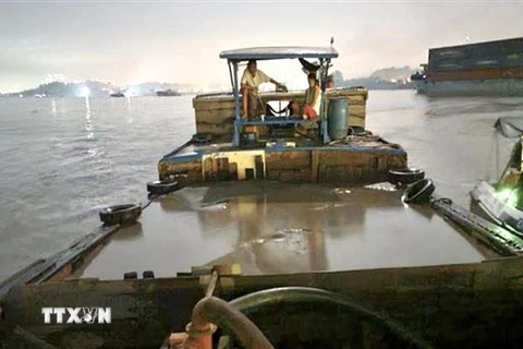 Lực lượng cảnh sát đường thủy tỉnh Đồng Nai phát hiện, kiểm tra phương tiện vận chuyển cát không rõ nguồn gốc. (Ảnh: TTXVN phát)