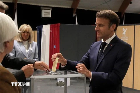 Tổng thống Pháp Emmanuel Macron (phải) bỏ phiếu bầu cử Quốc hội vòng hai tại Le Touquet ngày 19/6. (Ảnh: AFP/TTXVN)