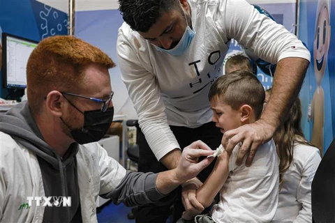 Nhân viên y tế tiêm vaccine ngừa COVID-19 cho trẻ em tại Jerusalem, Israel. (Ảnh: AFP/TTXVN)