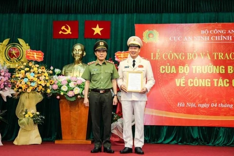 Thứ trưởng Lương Tam Quang trao quyết định, tặng hoa chúc mừng Thiếu tướng Vũ Hồng Văn, tân Cục trưởng Cục An ninh chính trị nội bộ. (Nguồn: Tiền Phong)